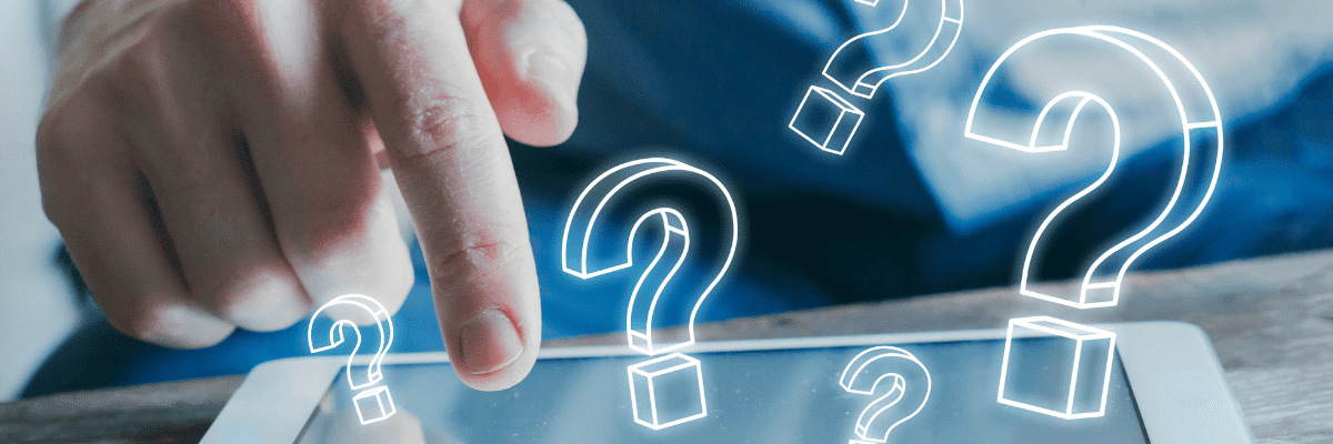 Hand pointing at question marks displayed on a tablet, illustrating frequently asked questions about mastering