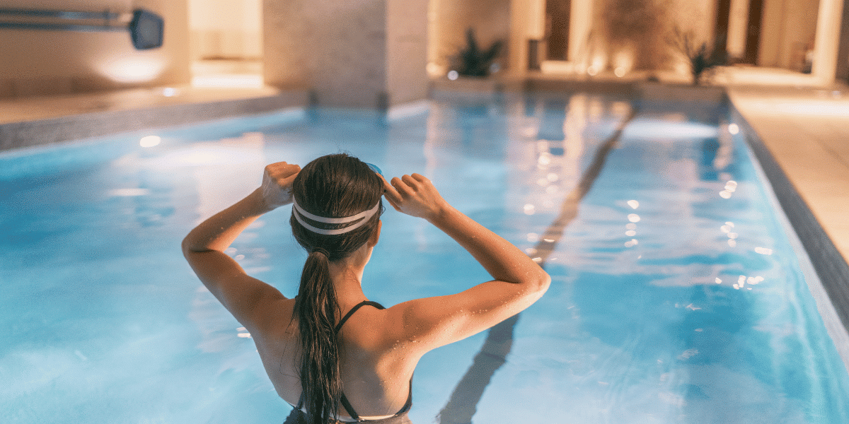 Woman preparing to swim in an indoor pool, highlighting a desirable condo amenity for Toronto