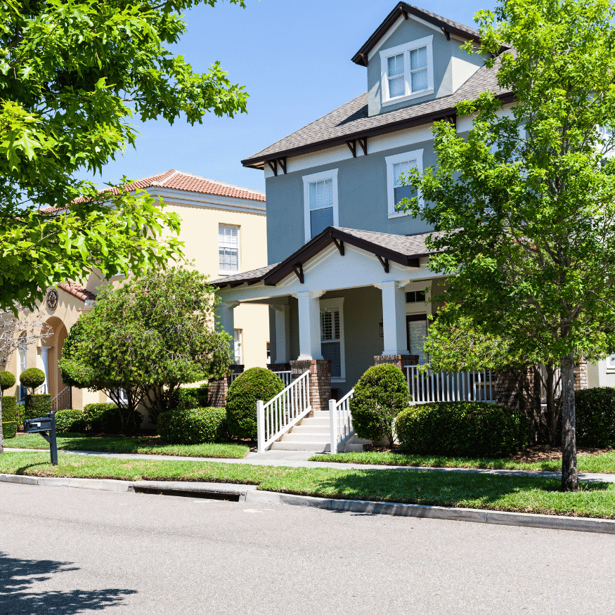 Exterior view of a two-story home with a red tile roof and well-manicured landscaping, illustrating
