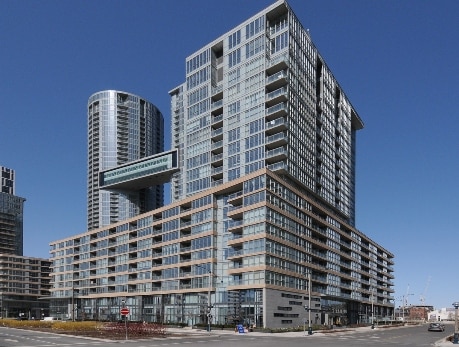 Modern CityPlace condo building in downtown Toronto, featuring a distinctive skybridge and waterfront views, ideal