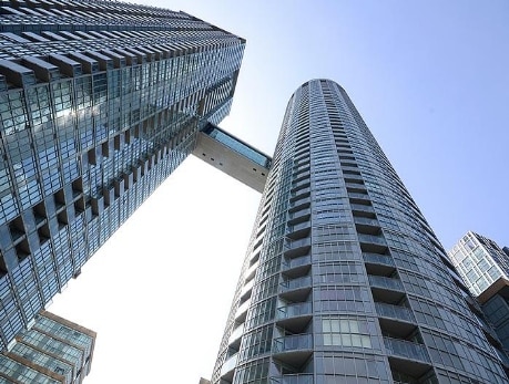 Modern condominium towers in CityPlace, Toronto, connected by a skybridge, showcasing waterfront living and City